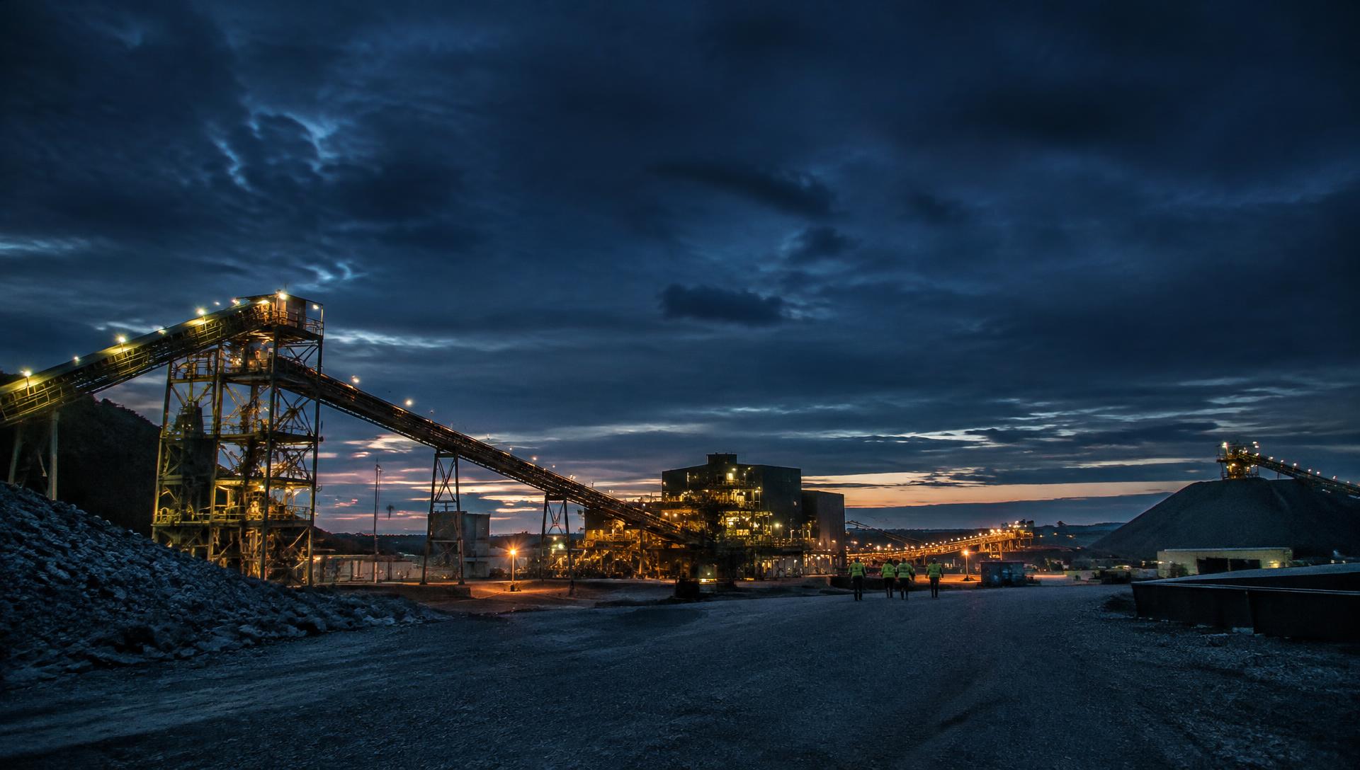 Industrial site with workers in hi-vis at dusk